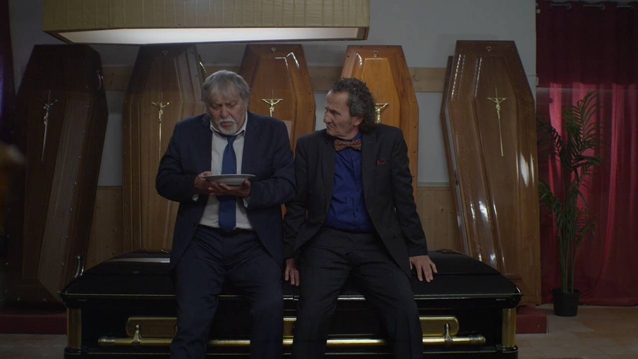Due famiglie, un funerale backdrop